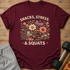 Maroon t-shirt with "Snacks, Stress, & Squats" floral graphic.
