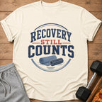 Cream t-shirt with "Recovery Still Counts" text and yoga mat illustration.