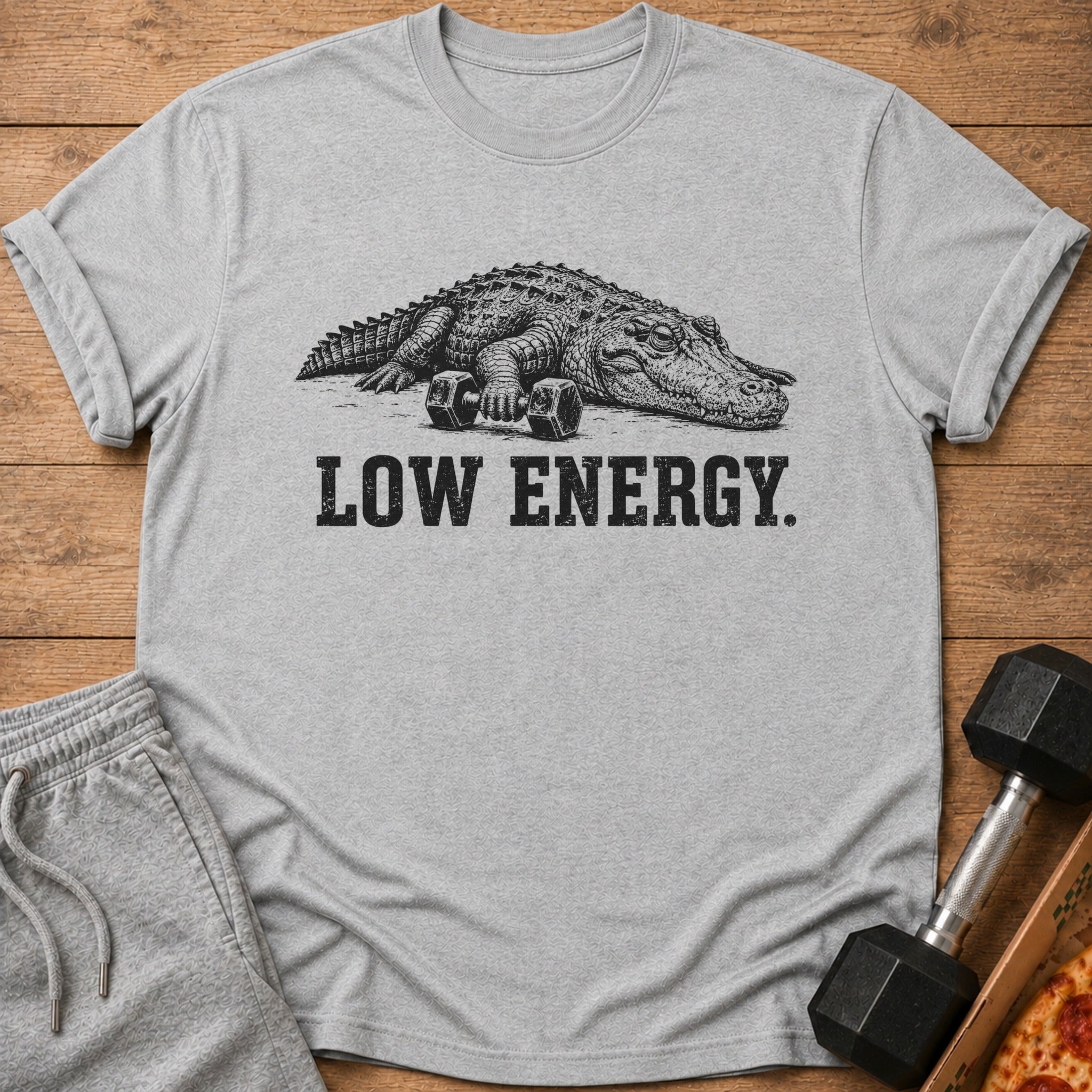 Alligator with dumbbells and text "LOW ENERGY." on a gray t-shirt.