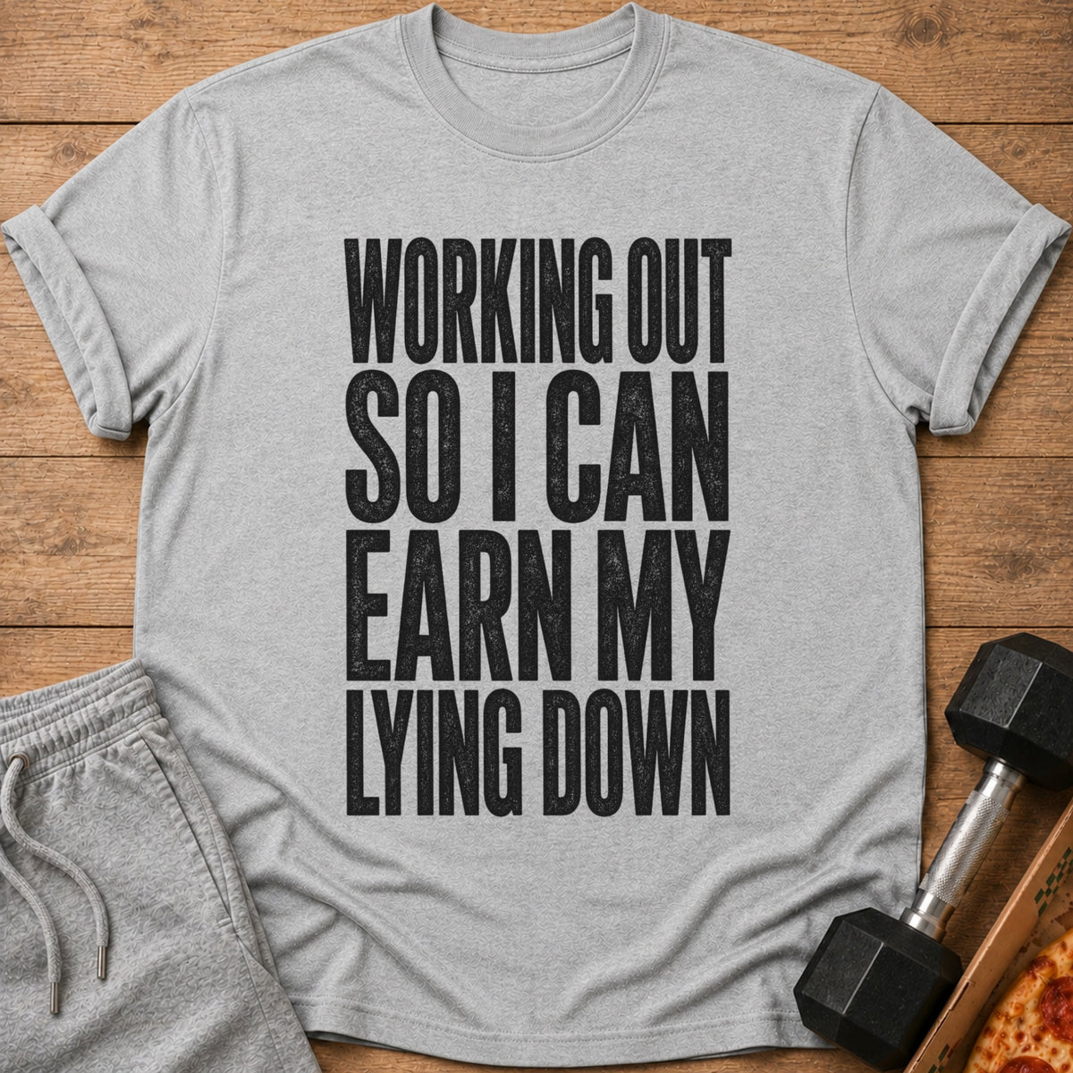Grey t-shirt with black text reading "Working Out So I Can Earn My Lying Down".