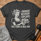 Dark t-shirt with retro woman holding cupcakes and text "I brought recovery cupcakes, they count as meal prep."