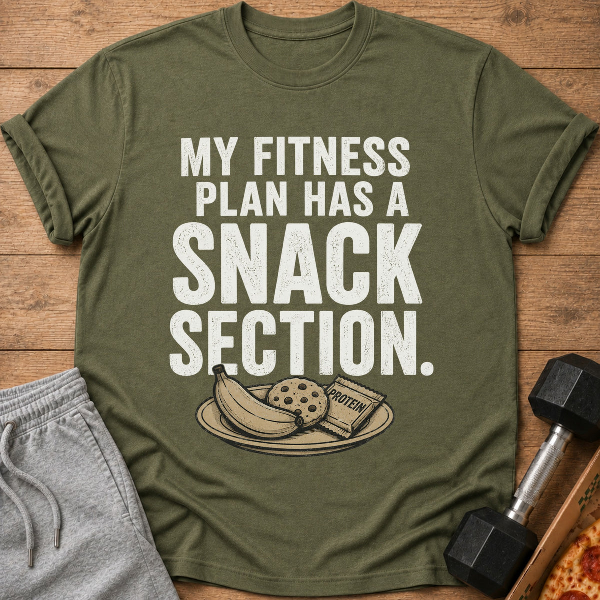 Green t-shirt with white text "MY FITNESS PLAN HAS A SNACK SECTION." and snacks illustration.