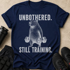 Navy t-shirt with capybara lifting weights, text reads "UNBOTHERED. STILL TRAINING."