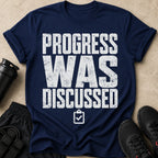 Navy t-shirt with "PROGRESS WAS DISCUSSED" and checklist graphic.