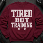 Maroon sweatshirt with white distressed text "TIRED BUT TRAINING" and a barbell graphic.
