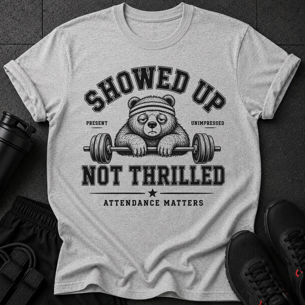 Grey t-shirt with a bear wearing a headband, holding a barbell, and text "SHOWED UP UNIMPRESSED" and "NOT THRILLED".