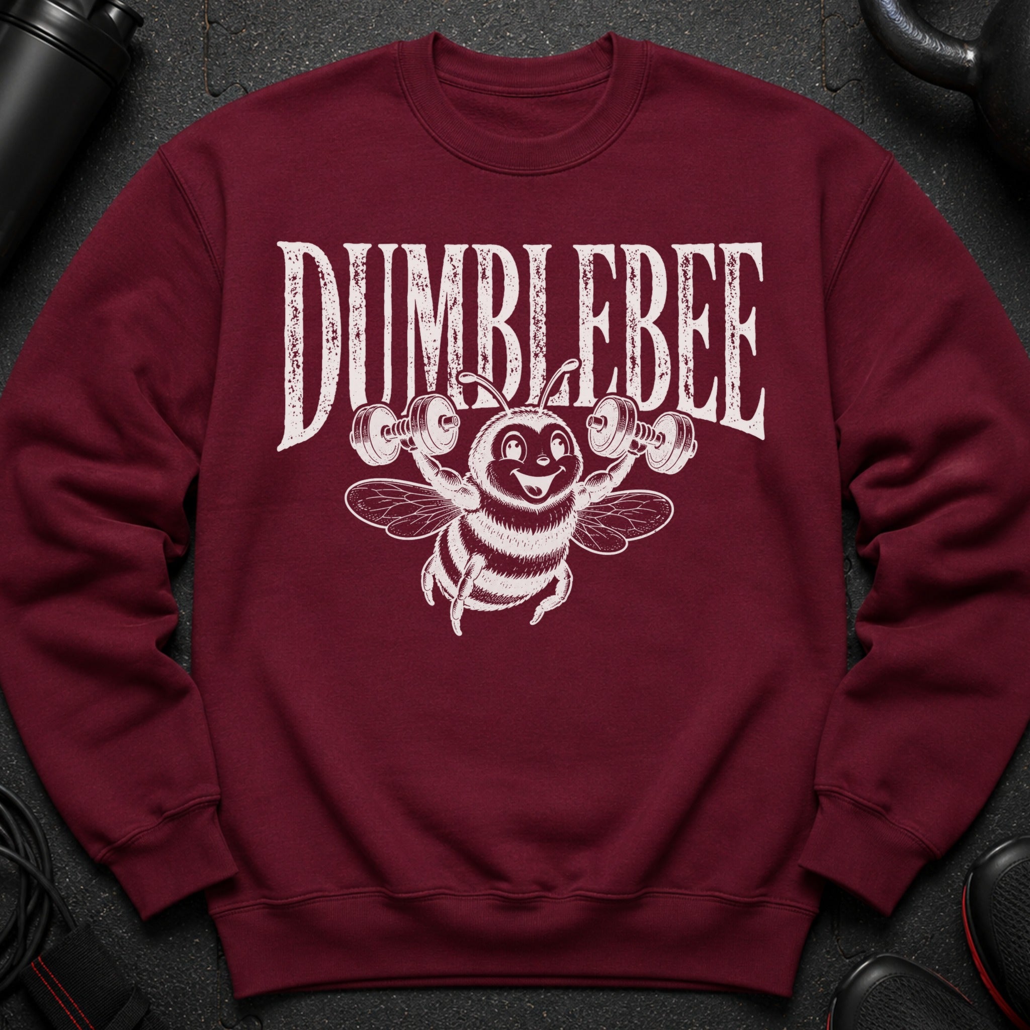Maroon sweatshirt with "DUMBLEBEE" text and a bee lifting dumbbells graphic.