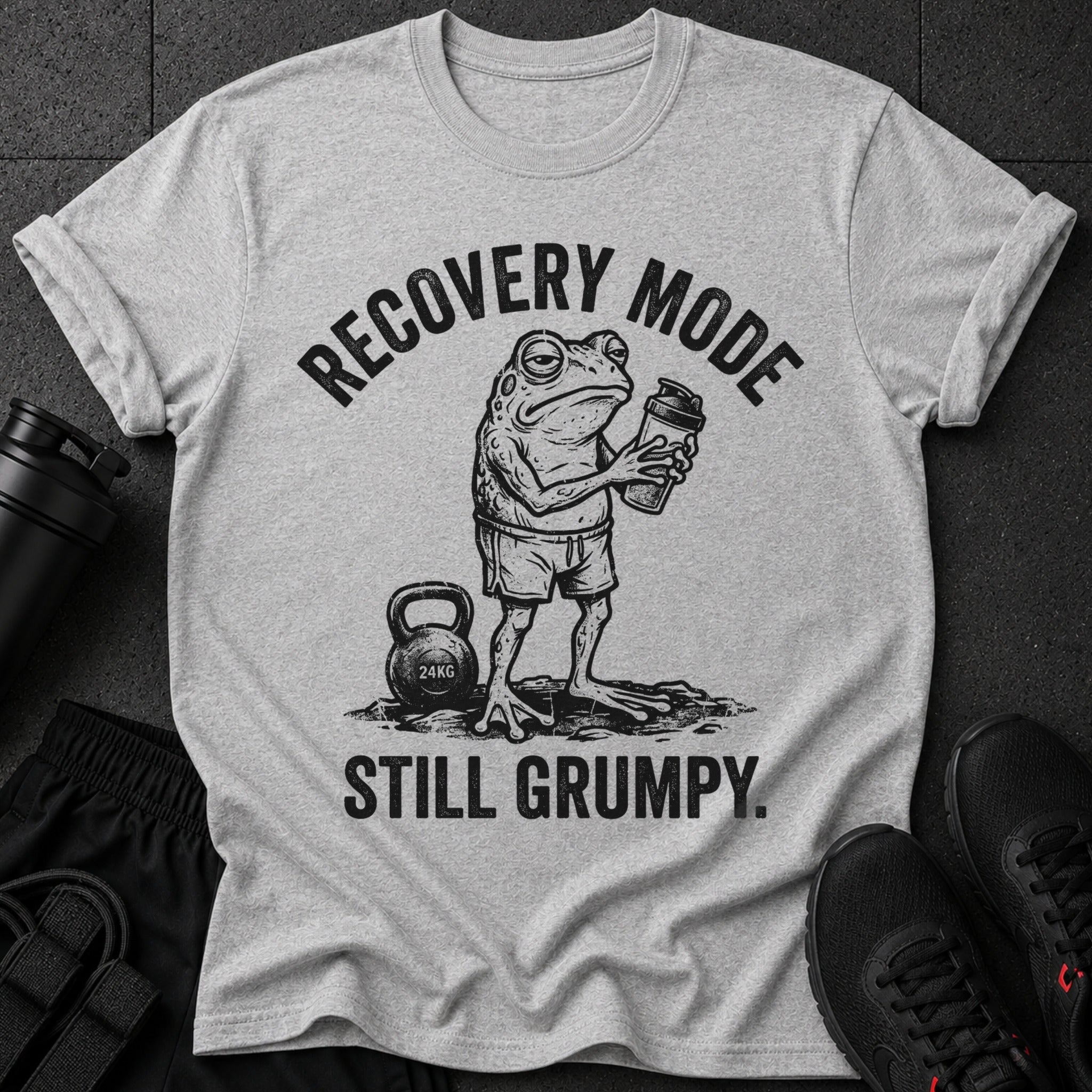 Grumpy frog in gym shorts holding a shaker bottle with text "RECOVERY MODE STILL GRUMPY."