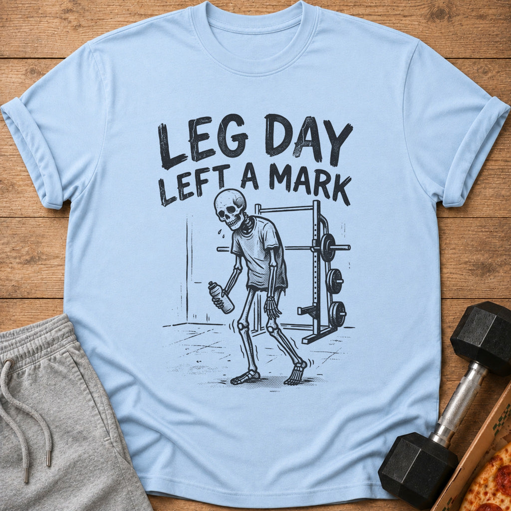 Light blue t-shirt with "LEG DAY LEFT A MARK" text and a skeleton at the gym.