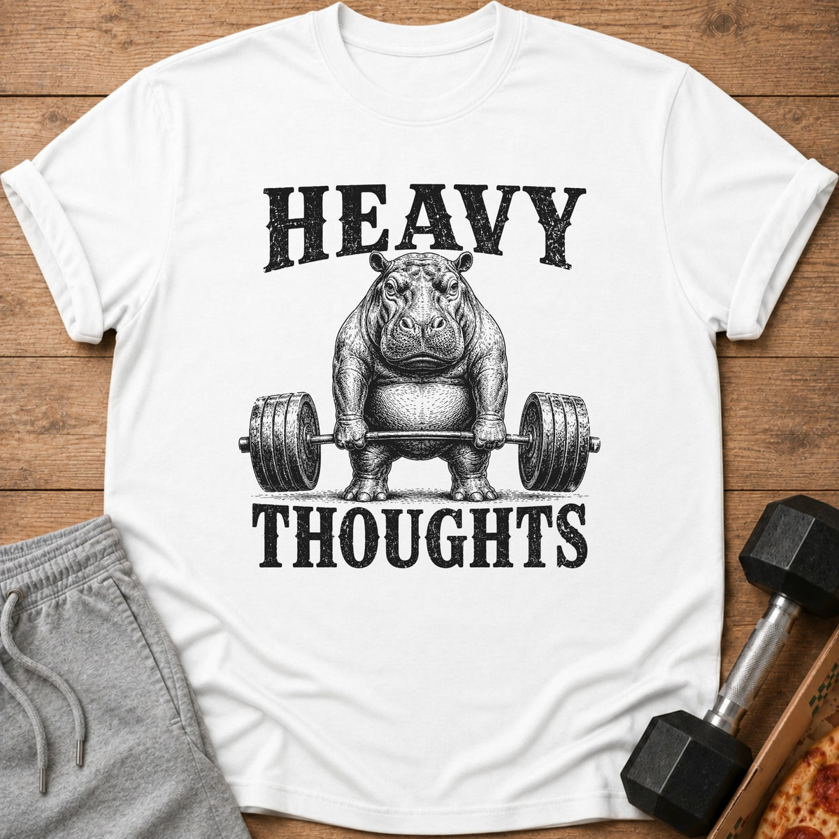 White t-shirt with a distressed graphic of a hippo lifting a barbell, reading "HEAVY THOUGHTS".