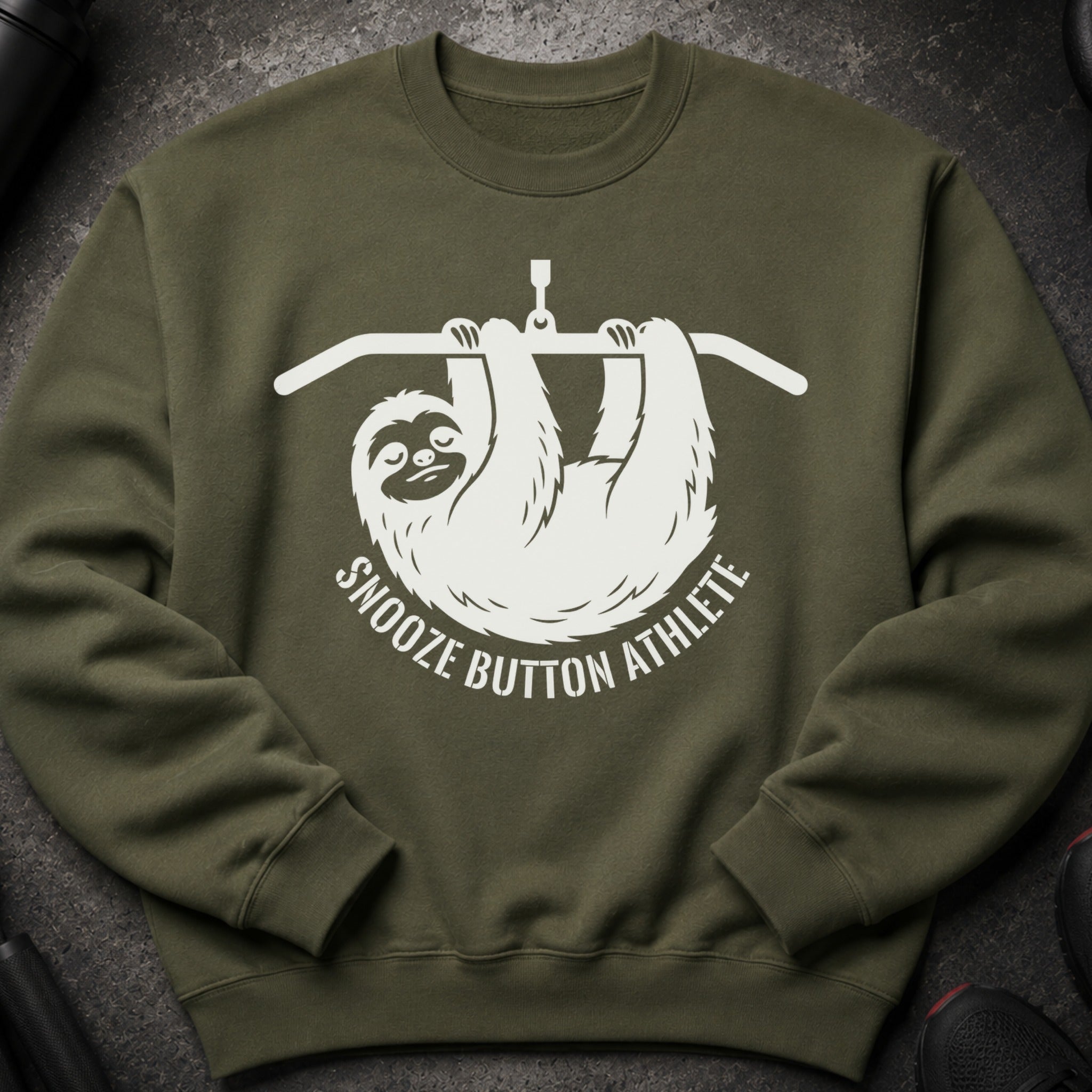 Green sweatshirt with white graphic of a sloth on a pull-up bar saying "Snooze Button Athlete".