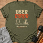 Olive green t-shirt graphic with "USER ERROR" and a dejected figure next to a treadmill.