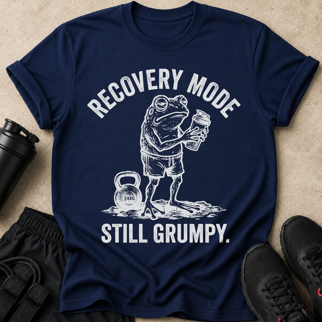Navy t-shirt with distressed white graphic of a frog holding a protein shaker and a 24kg kettlebell. Text reads "RECOVERY MODE STILL GRUMPY."