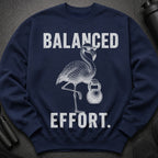 Navy sweatshirt with a drawing of a flamingo lifting a kettlebell. Text says "BALANCED EFFORT."