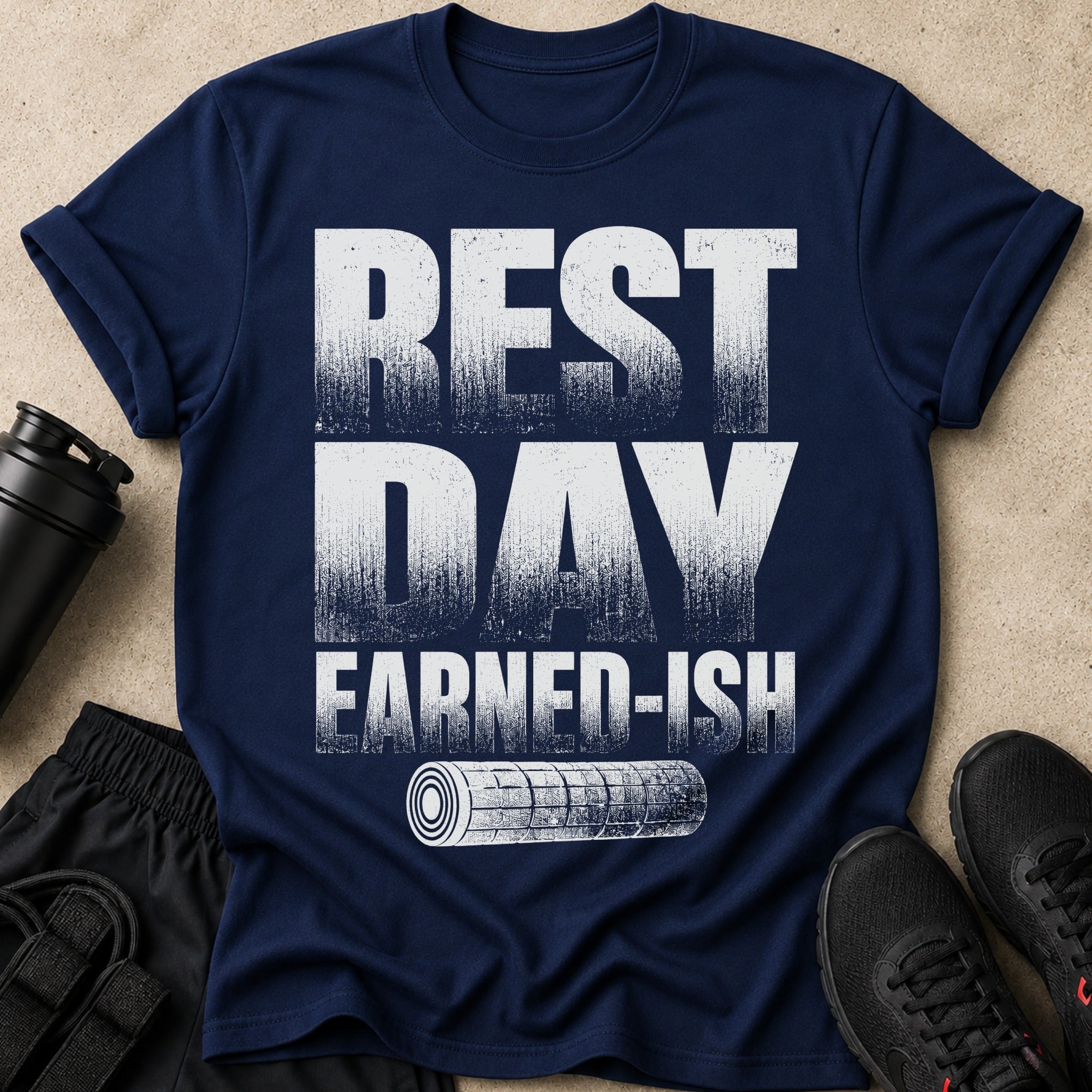 Navy t-shirt with distressed white text "REST DAY EARNED-ISH" and a graphic of a foam roller.