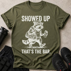 This t-shirt features a graphic of a raccoon with a gym bag and a protein shaker.