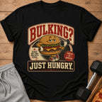 Black t-shirt with a cartoon burger lifting weights, text "Bulking? Just Hungry."