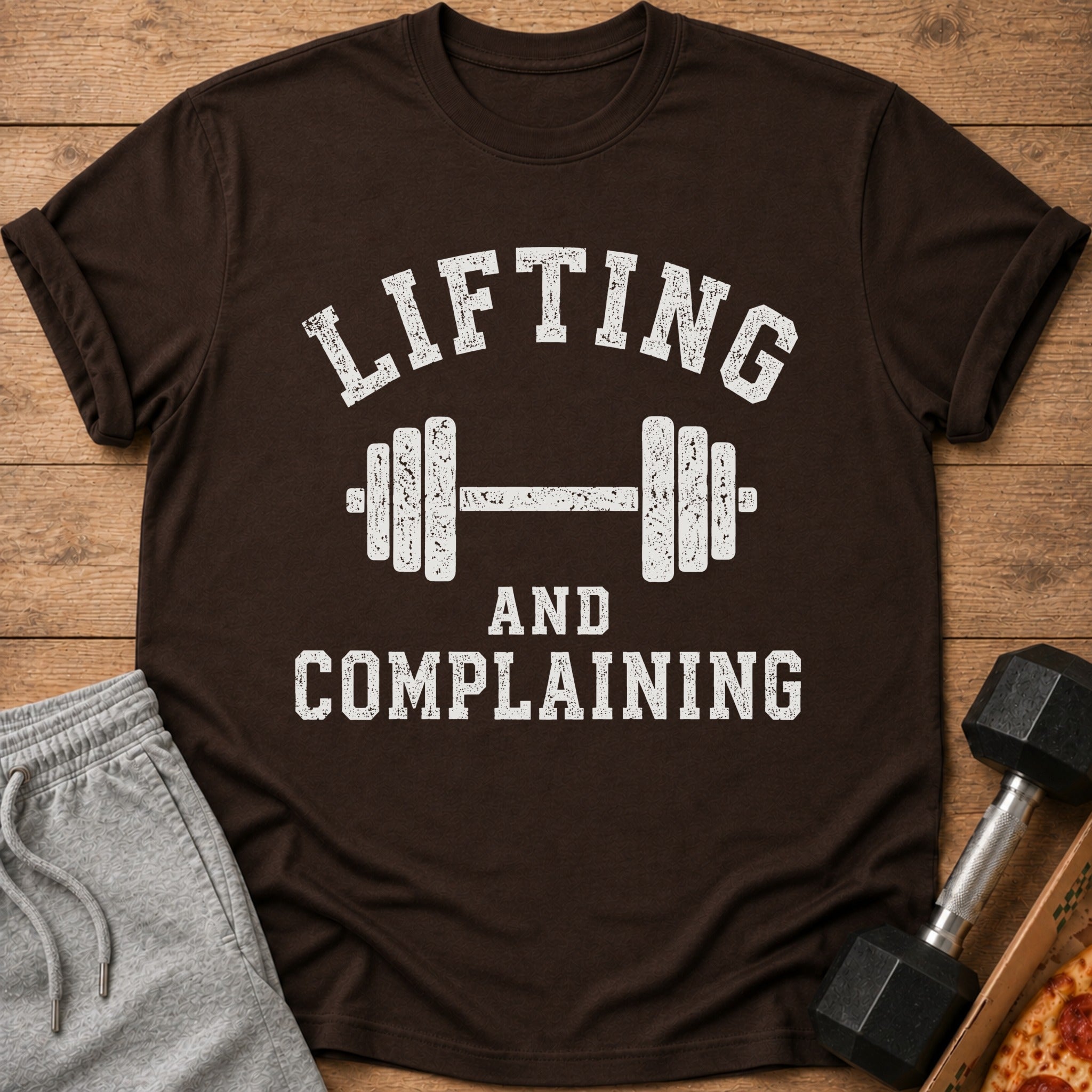 Brown t-shirt with distressed white text "LIFTING AND COMPLAINING" and a dumbbell graphic.