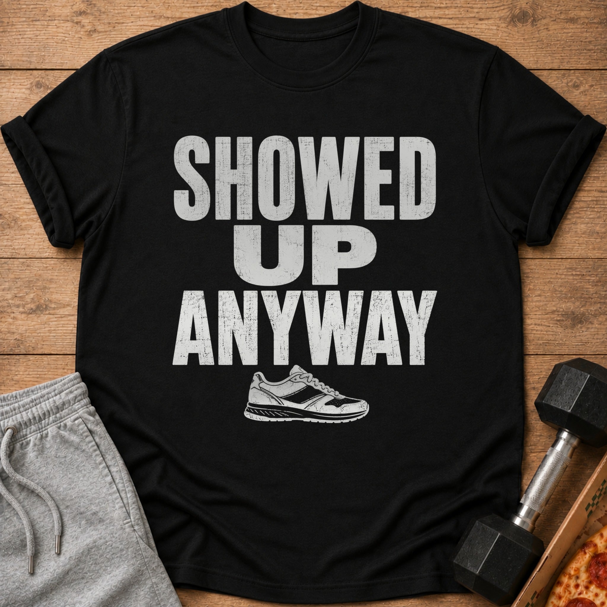 Black t-shirt with distressed white text "SHOWED UP ANYWAY" and a sneaker graphic.
