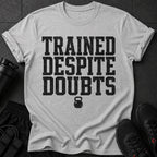 Grey t-shirt with black text "TRAINED DESPITE DOUBTS" and kettlebell graphic.