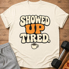 T-shirt with text "SHOWED UP TIRED." and a coffee cup graphic.
