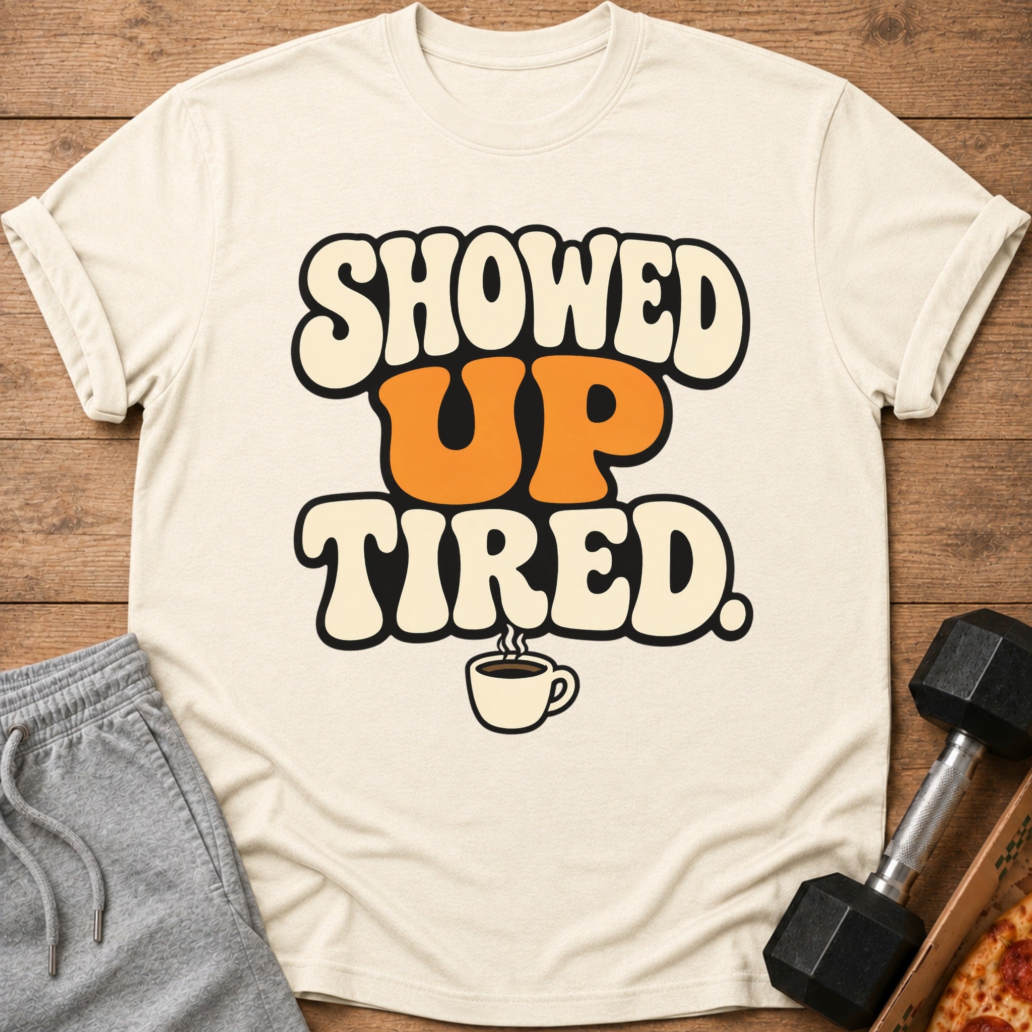 T-shirt with text "SHOWED UP TIRED." and a coffee cup graphic.