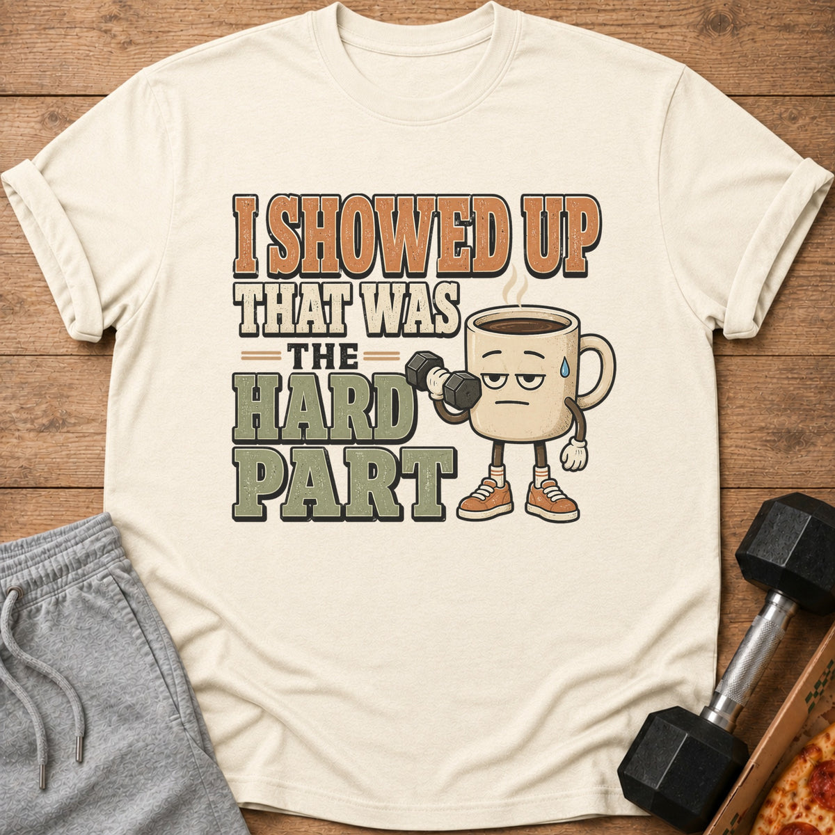 Cream t-shirt with coffee mug lifting dumbbell and text "I showed up, that was the hard part".