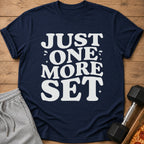 Navy t-shirt with white text "JUST ONE MORE SET" and workout accessories.