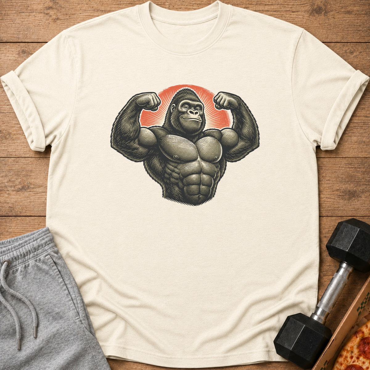 Muscular gorilla flexing biceps in front of a sunburst on a cream t-shirt.
