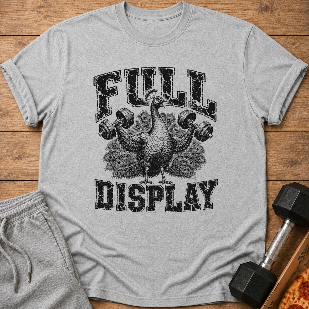 A heather grey t-shirt features a black graphic of a peacock lifting dumbbells with the text FULL DISPLAY.