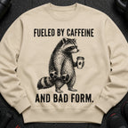 Crewneck sweatshirt with raccoon lifting weights and holding coffee, text "Fueled by caffeine and bad form."