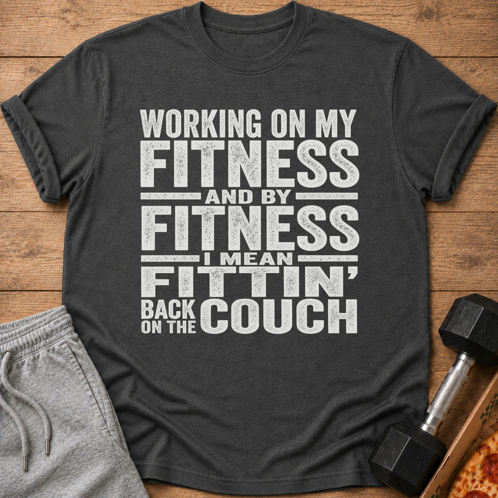 Dark t-shirt with white text "Working on my fitness and by fitness I mean fittin' back on the couch."