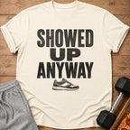 Cream t-shirt with "SHOWED UP ANYWAY" text and a sneaker graphic.