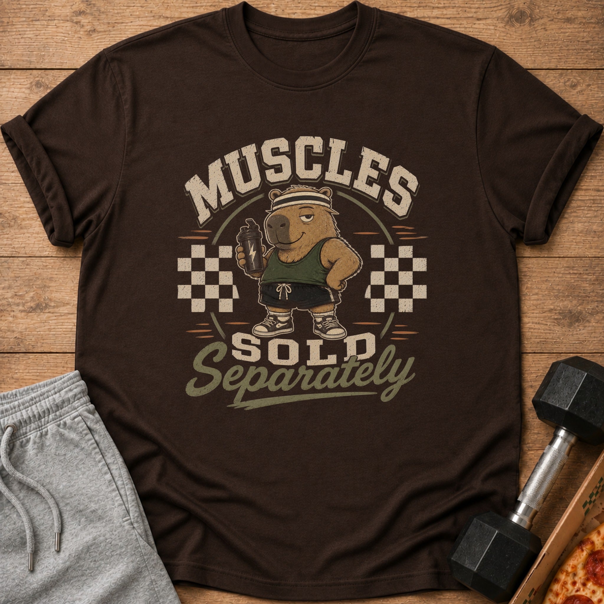 Brown t-shirt with graphic of capybara holding shaker, text "Muscles Sold Separately".