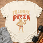T-shirt with graphic of muscular man holding pizza slice, text reads "Training for Pizza".