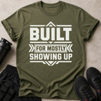 Olive green t-shirt with bold white text: BUILT FOR MOSTLY SHOWING UP.
