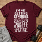 Maroon t-shirt with white text and graphic about developing trust issues with stairs.
