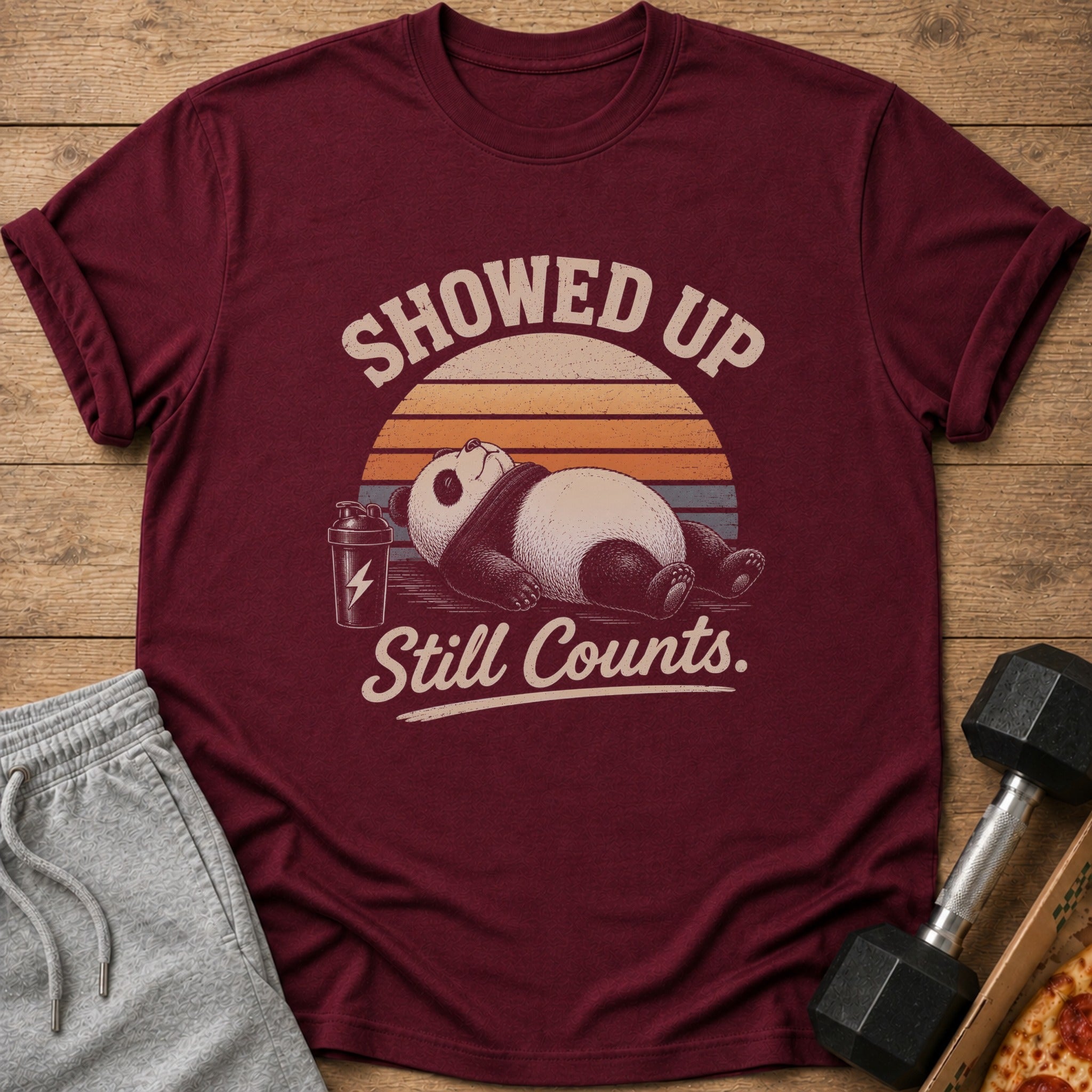Maroon t-shirt with a panda and text "Showed Up Still Counts."
