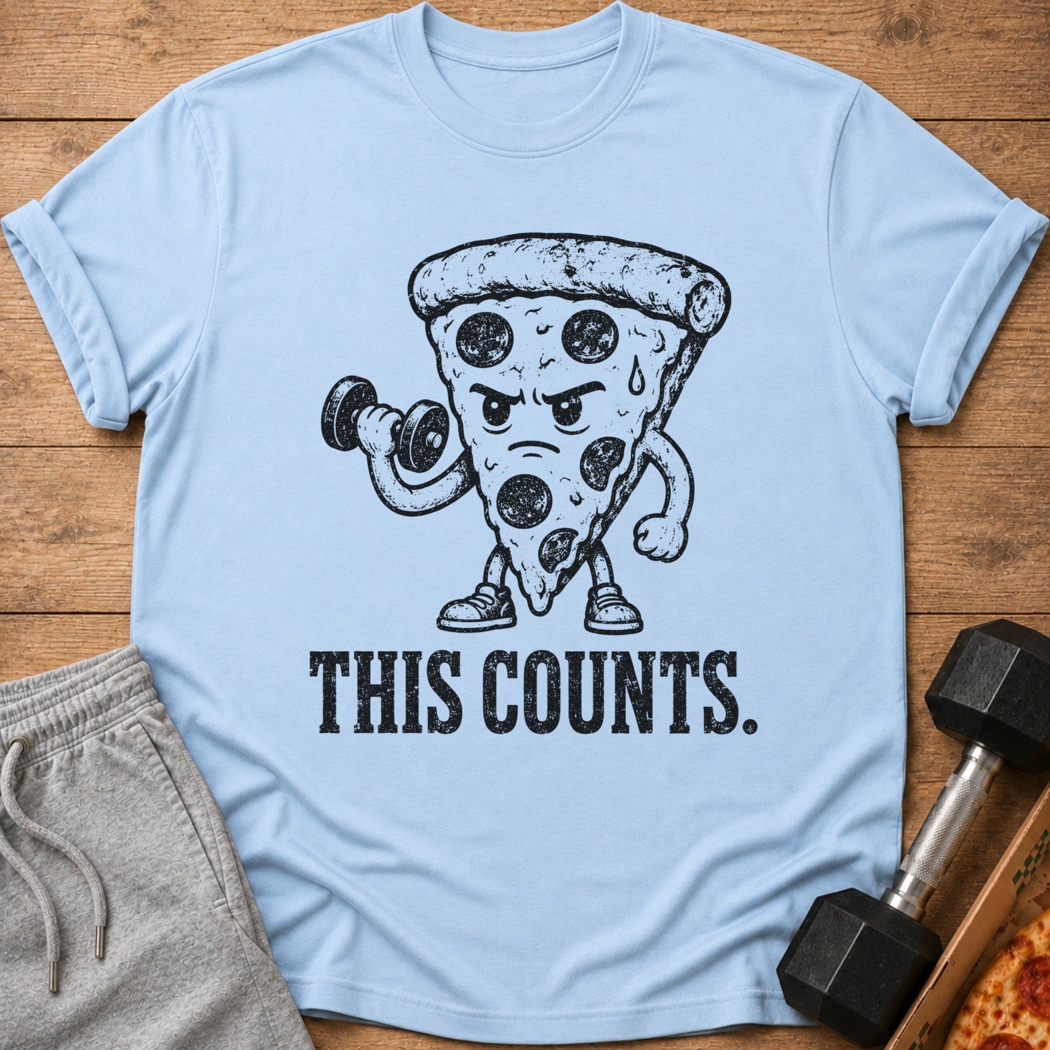 Light blue t-shirt with cartoon pizza lifting a dumbbell and text "THIS COUNTS."