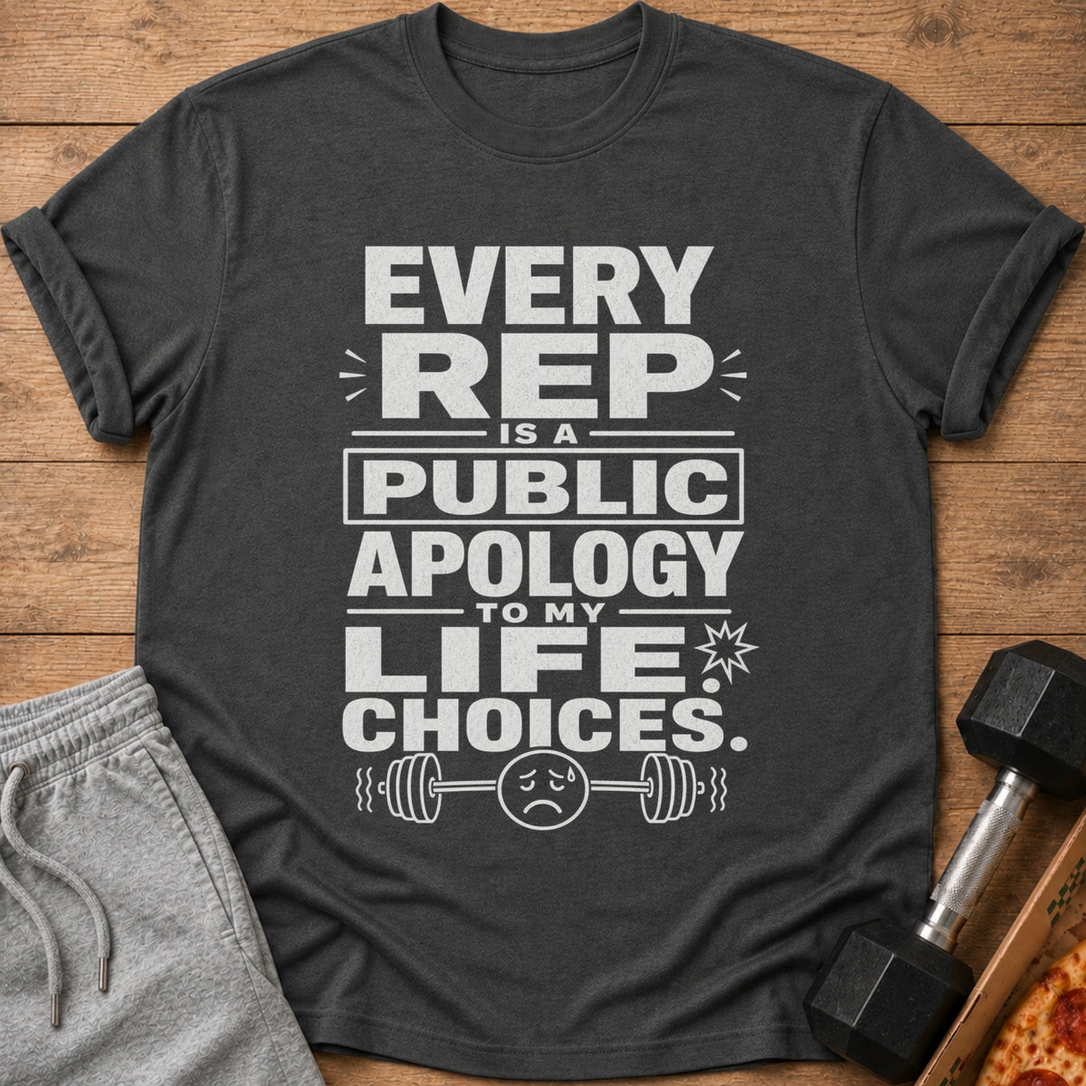 Dark grey t-shirt with white text "EVERY REP IS A PUBLIC APOLOGY TO MY LIFE CHOICES" and barbell graphic.