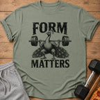 Green t-shirt with a peacock lifting a barbell; "FORM MATTERS" text.