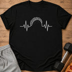 Black t-shirt with white taco heartbeat graphic, placed next to sweatpants and dumbbell.