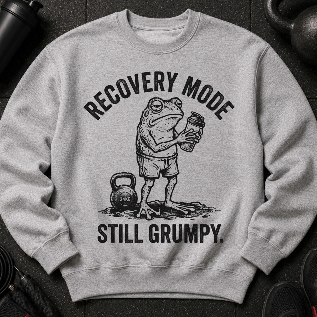 Grey sweatshirt with a drawing of a grumpy frog holding a shaker bottle and the text "RECOVERY MODE STILL GRUMPY."