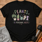 Black t-shirt with "PLANTS & PERSONAL BESTS" and cute cartoon plants and gym items.