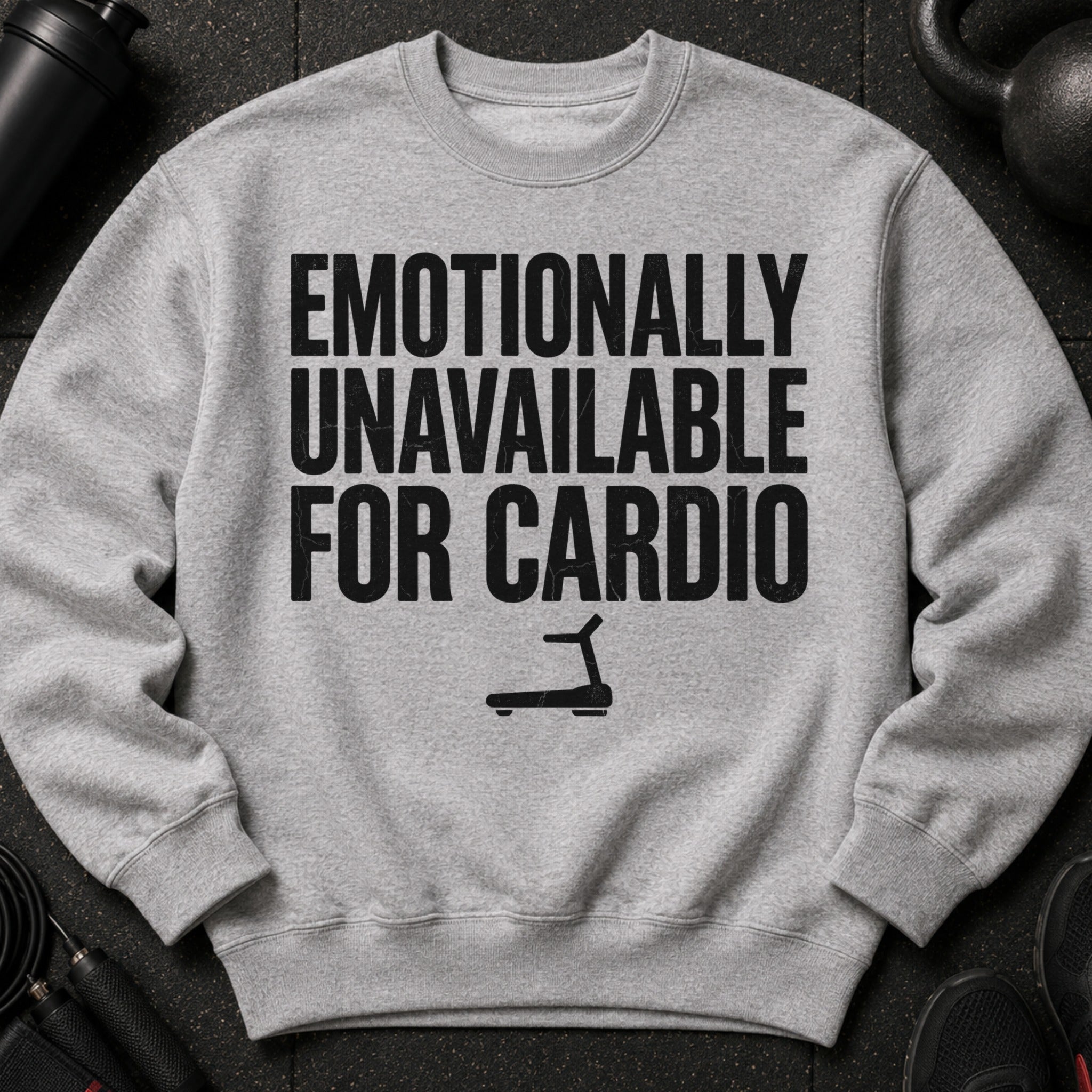 Gray sweatshirt with black text "Emotionally Unavailable For Cardio" and treadmill graphic.