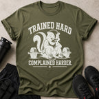 Green t-shirt with skunk lifting weights and text "TRAINED HARD COMPLAINED HARDER."