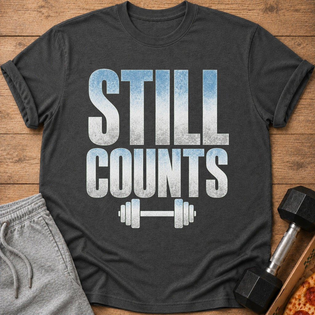 Dark t-shirt with distressed text "STILL COUNTS" and a barbell graphic.