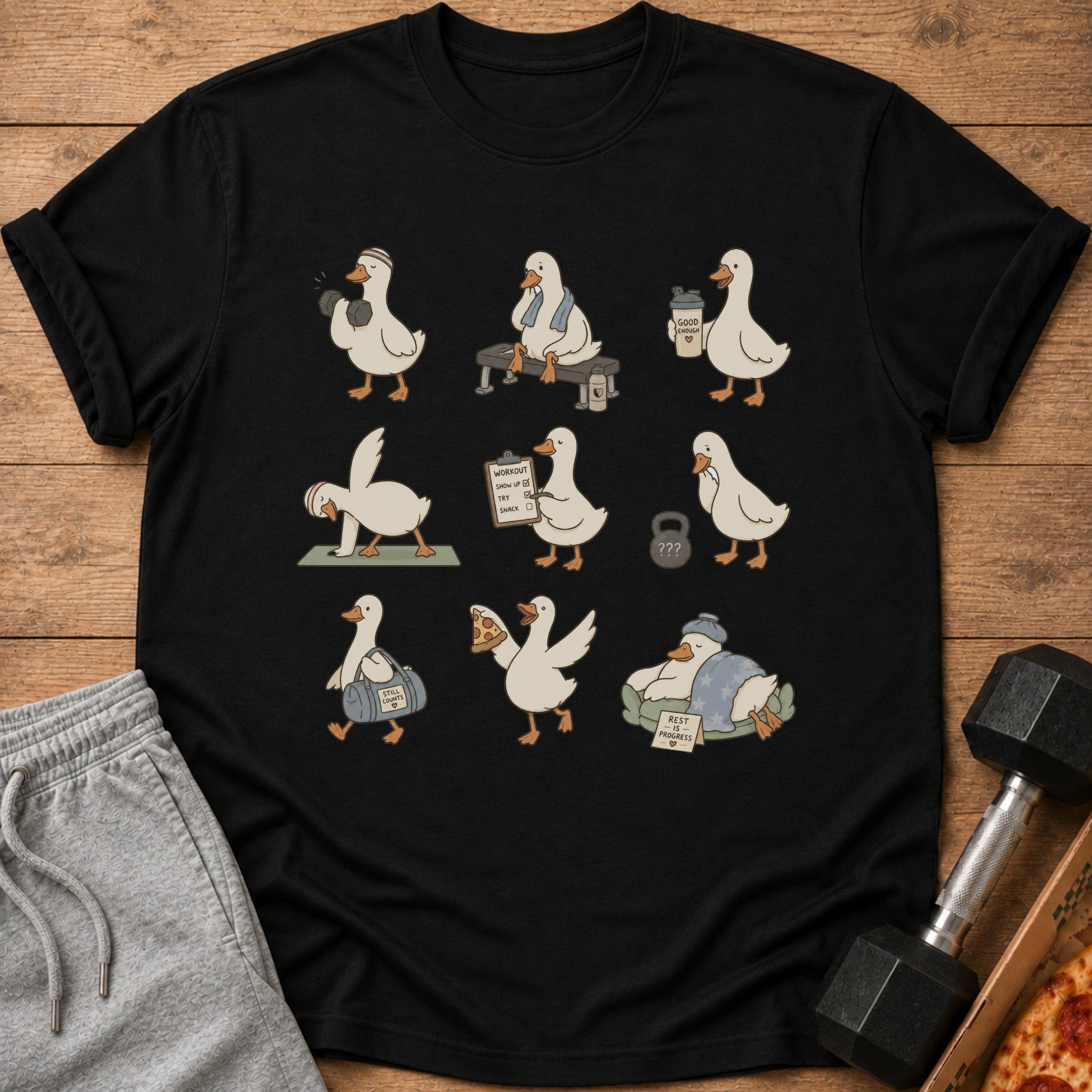 Black t-shirt with cartoon geese doing various fitness and relaxation activities.
