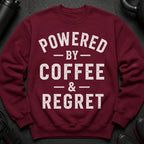 Maroon sweatshirt with distressed white text "POWERED BY COFFEE & REGRET".