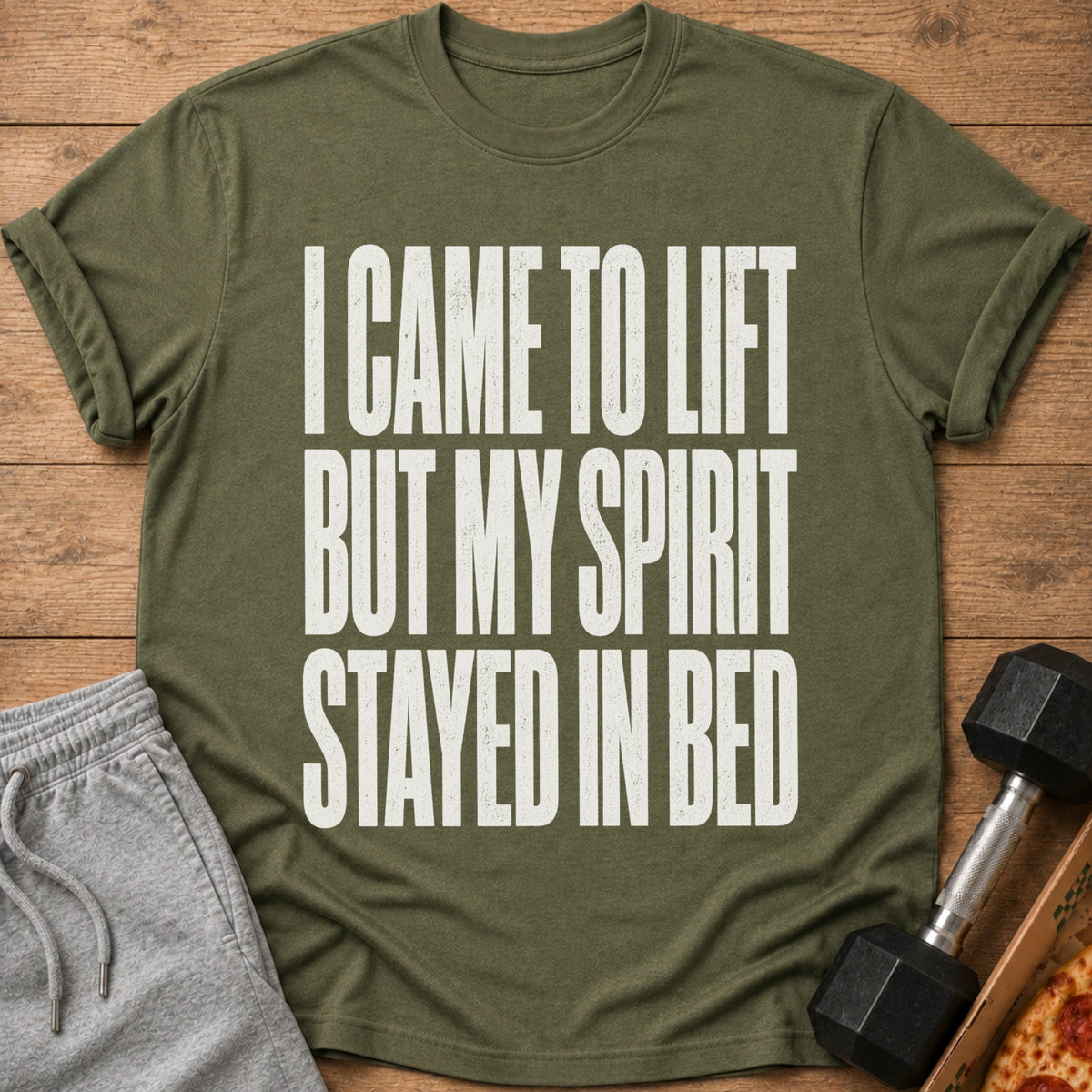 Olive green t-shirt with white text: "I CAME TO LIFT BUT MY SPIRIT STAYED IN BED."